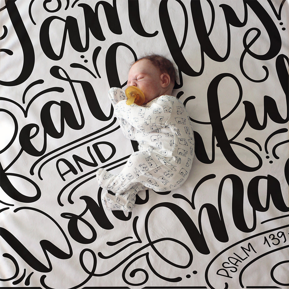 a baby is sleeping on a blanket with lettering on it