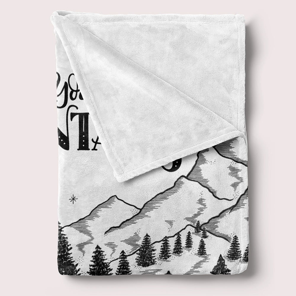 a white blanket with a mountain scene on it